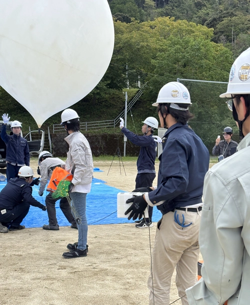 本番の様子小型気球に機器をつなぎ放球の画像