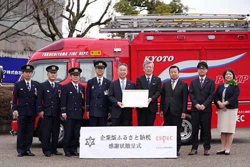 当社寄附による消防ポンプ自動車の前にて